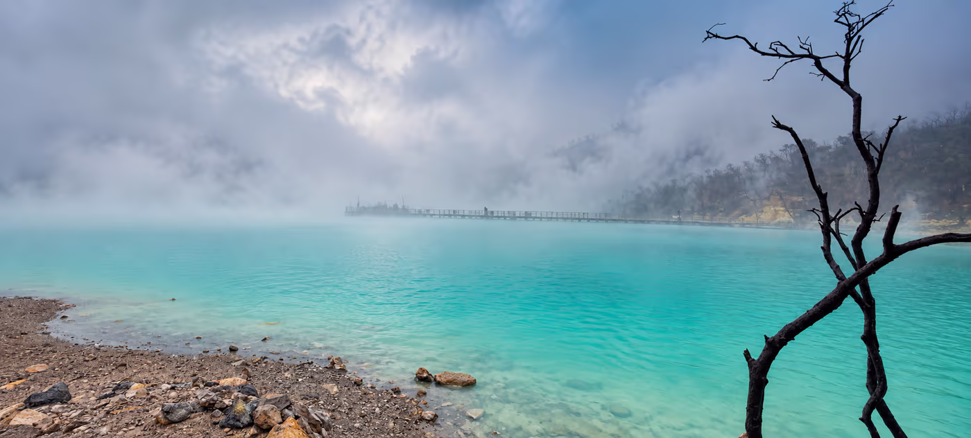 Pemandangan danau wisata berkabut dengan air biru kehijauan